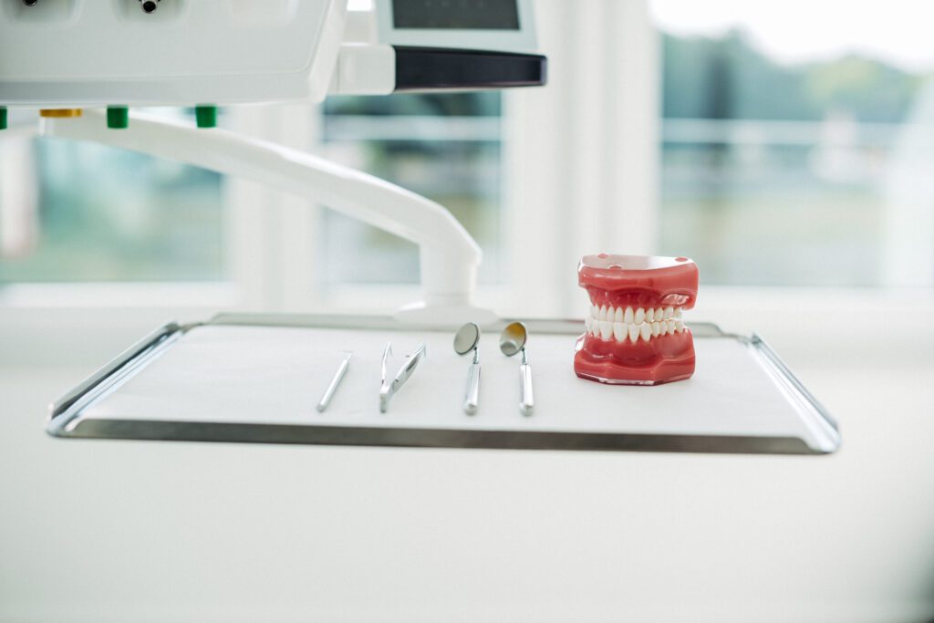 Zahnärztliches Besteck und ein Gebissmodell auf einem Behandlungstisch in der Kieferorthopädiepraxis – vorbereitet für eine Beratung zur Lingualtechnik mit WIN.