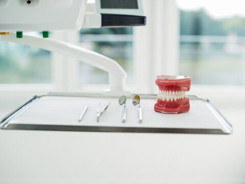 Zahnärztliches Besteck und ein Gebissmodell auf einem Behandlungstisch in der Kieferorthopädiepraxis – vorbereitet für eine Beratung zur Lingualtechnik mit WIN.